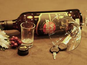 Car keys next to empty alcohol bottle.