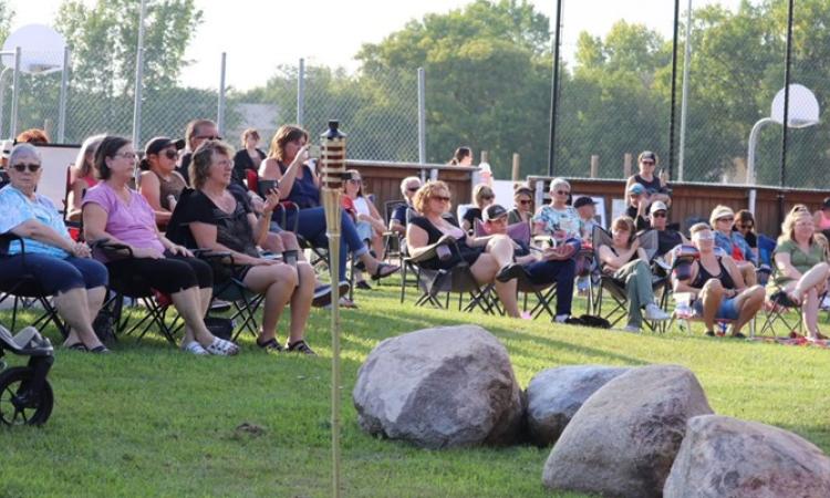 Visitors gather for a concert in the park last summer in Grande Pointe.
