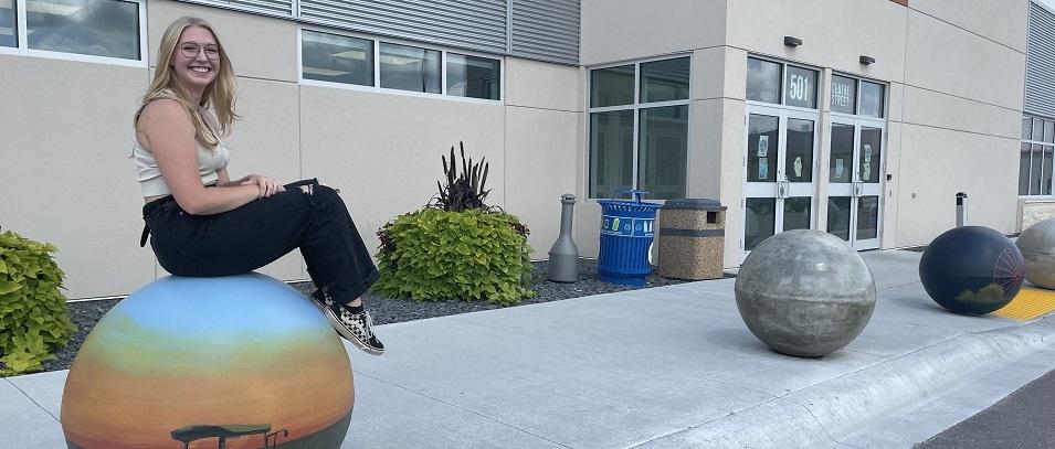 Jessica Banman and her paintings on the CRRC bollards.