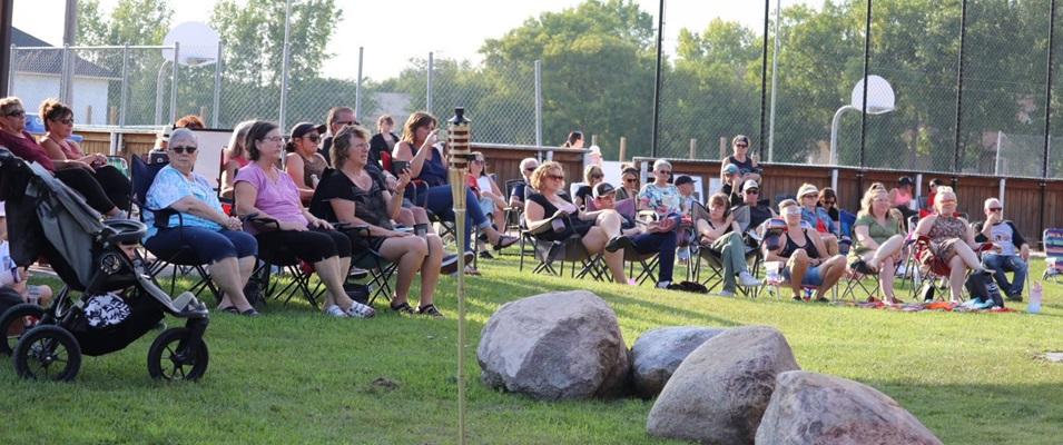 Visitors gather for a concert in the park last summer in Grande Pointe.