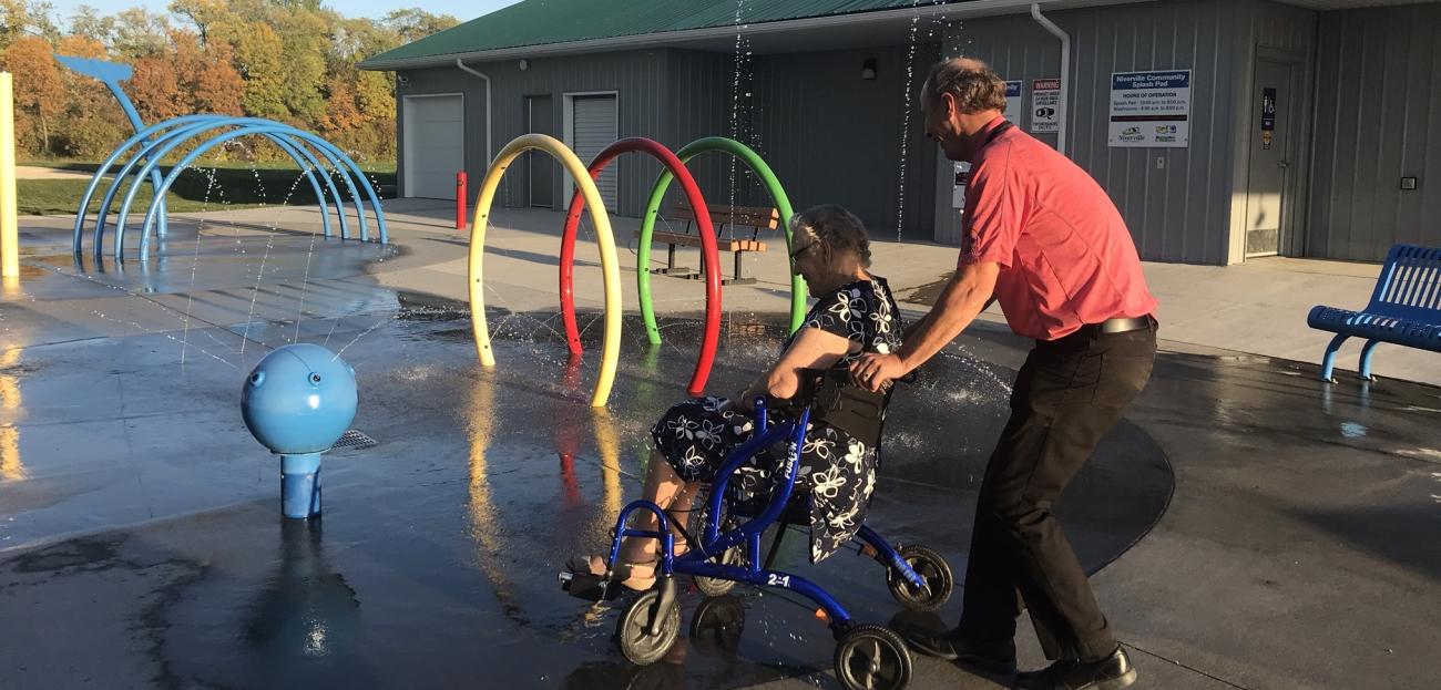 91-year-old Emily Fast wheels through the splash pad.