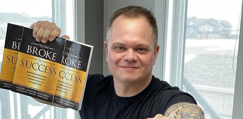 Derek Loepp with copies of the book he contributed to.
