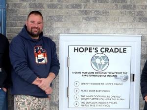 Hope’s Cradle installers Zack Ronaldson and Allan Ward alongside Susan Penner, executive director of Life Culture.