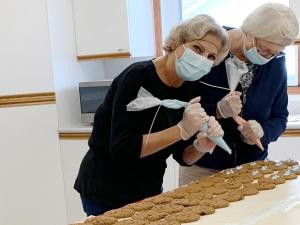 Volunteers Evelyn Mcfarlane and Jeanette Fast decorate Smile Cookies at the Golden Friendship Centre.