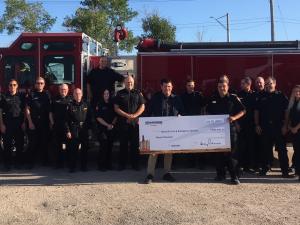 Greg Knox of Richardson International presents a donation cheque to Fire Chief Keith Bueckert.