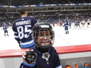 Ryder Couzens of Niverville sits on the bench at a Jets home game warm-up.
