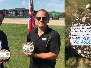 MLA Ron Schuler and Ritchot Mayor Chris Ewen, displaying transfer of ownership keepsakes made from the road's asphalt surface.
