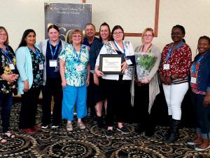 Team members of the Heritage Life Personal Care Home, with Dorothy Lapointe holding her award certificate.