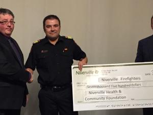 Andrew Neufeld and Ken Rempel of the Niverville Health and Community Foundation board present a donation to Fire Chief Keith Bueckert.