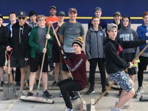 Rush players build some sweat equity by sweeping the Wm. Dyck & Sons parking lot in exchange for a generous donation