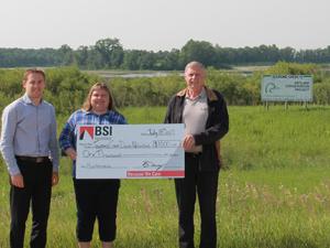 BSI's Ryan Haps and Jake Neufeld present a cheque to Nicole DePauw, Tourond Creek Committee Treasurer