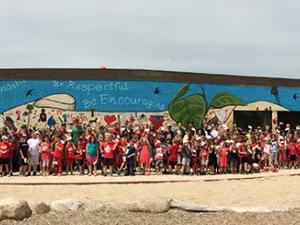 Students celebrate the completion of the Canada 150 mural at Ecole St. Adolphe School