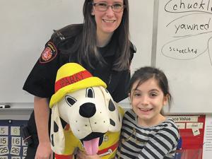Calysta Guenette poses alongside Sparky the Fire Dog and paramedic firefighter Tara Fehr