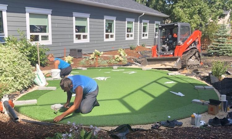 Installing the putting green at the Memory Garden at Niverville's PCH.