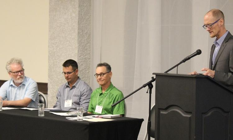 Bruce Duggan of Providence College (Otterburne), Paul Neufeld of Southern Comfort Mechanical (Niverville), and Gary McFarlane of Titan Environment Containment (Île-des-Chênes) speak on a panel moderated by Darren Swanson of the International Institute for Sustainable Development.