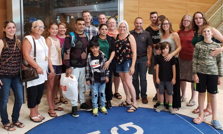 A refugee family is greeted at the Winnipeg airport by members of Open Doors Niverville.
