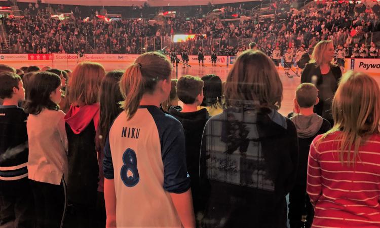 Music teacher Susan Simcoe leads the Niverville Elementary School choir in singing the national anthem at Bell MTS Place on November 17.