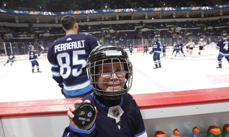 Ryder Couzens of Niverville sits on the bench at a Jets home game warm-up.