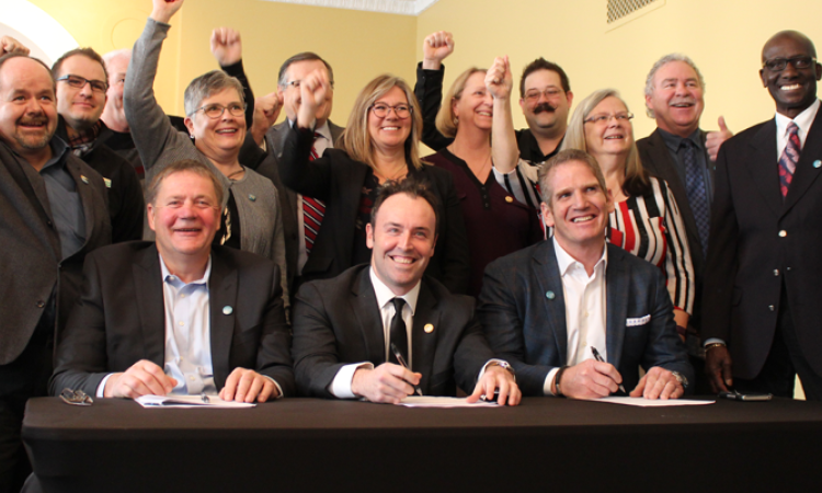 The mayors and reeves of JohnQ Public announce a new high-speed internet initiative. At the table: Macdonald Reeve Brad Erb, Chris Kennedy of RFNow Inc., and Rob Barlow of WireIE Inc.