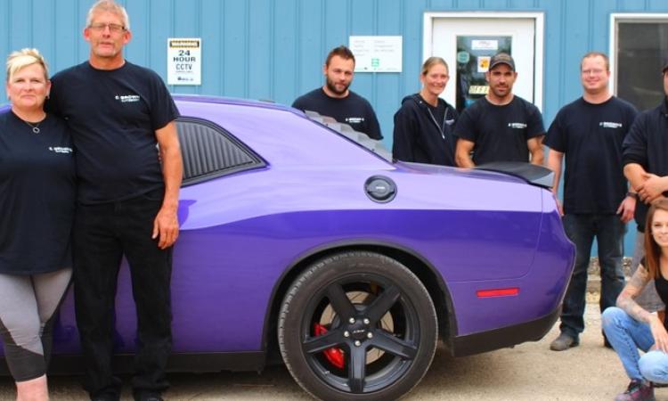 Carol Brown with her husband Brian and autobody staff.