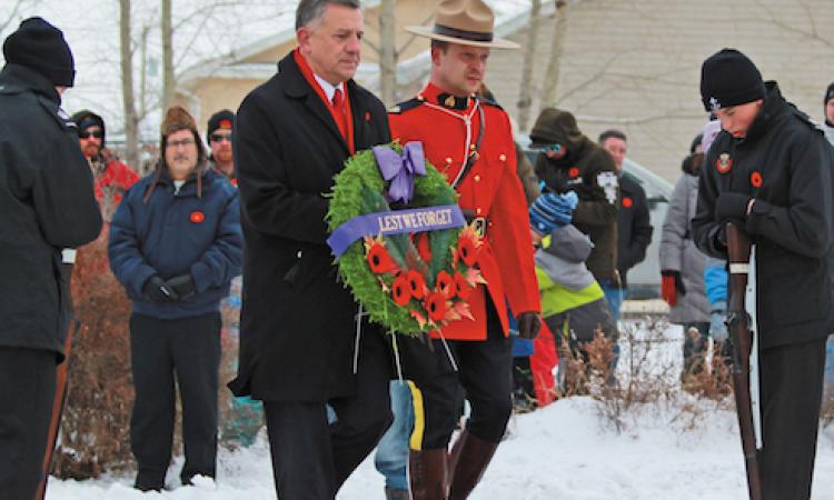 MP Ted Falk lays a wreath at a Remembrance Day ceremony in Lorette