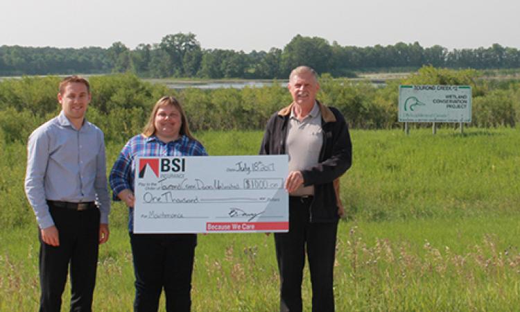 BSI's Ryan Haps and Jake Neufeld present a cheque to Nicole DePauw, Tourond Creek Committee Treasurer