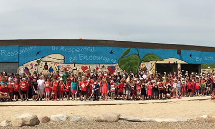 Students celebrate the completion of the Canada 150 mural at Ecole St. Adolphe School