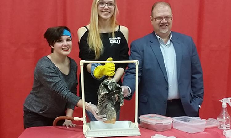 Kianne Prudhomme, Shelah Klassen, and the Hon. Kelvin Goertzen examine a mock-up of a diseased lung