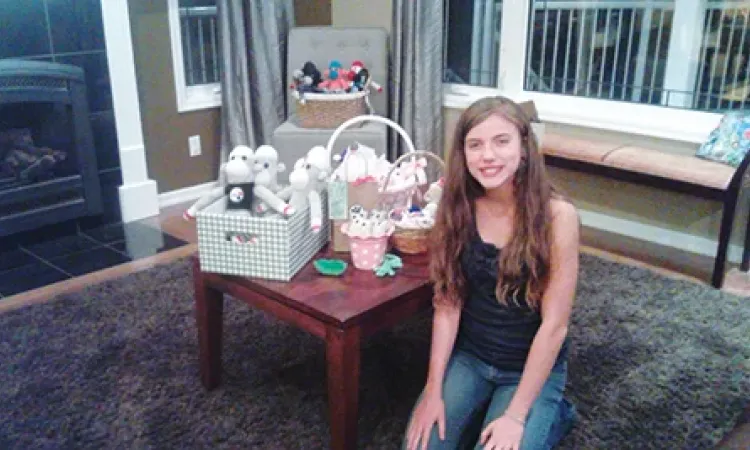 Briana Bloom, 14, poses with her sock puppet creations