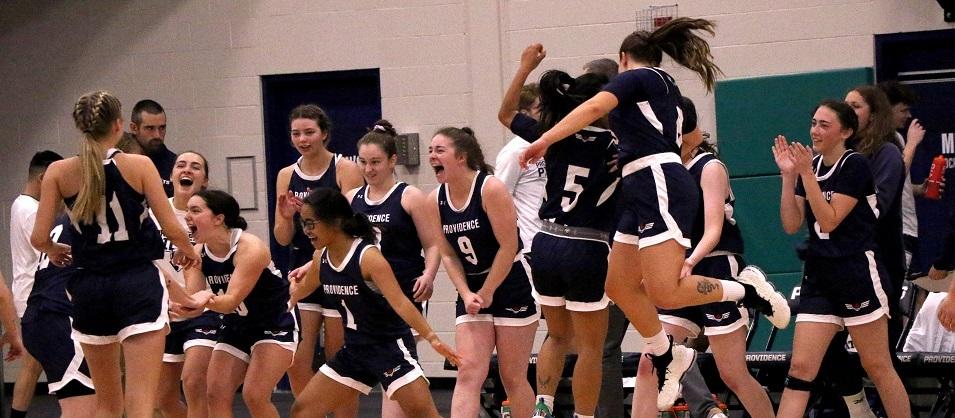 The women's basketball team celebrates a hard-fought victory.