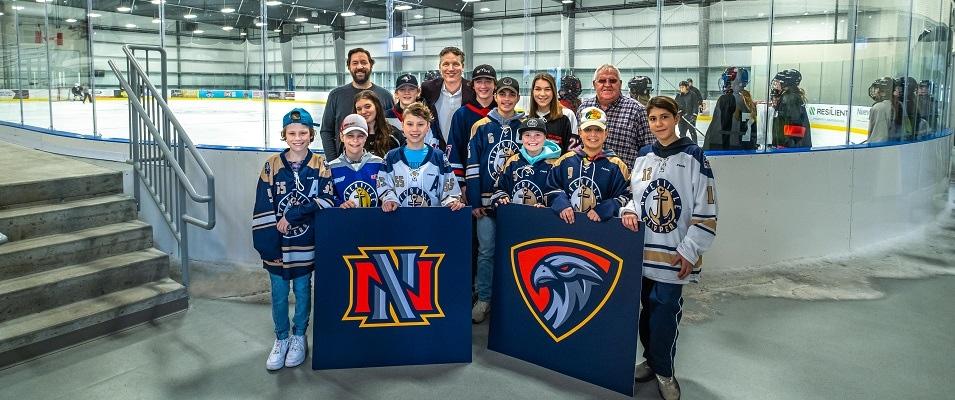 Nighthawks board members Jeremy Braun, Ray Dowse, and Clarence Braun show off the new logo with local hockey and ringette players.
