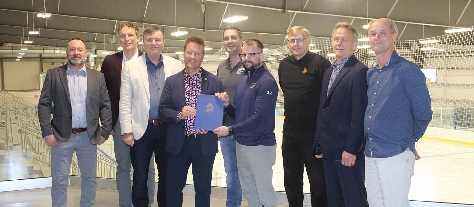 Nighthawks board members Bryan Trottier and Ray Dowse, Mayor Myron Dyck, MLA Ron Schuler, Councillor Nathan Dueck, Nighthawks Head Coach Kelvin Cech, Deputy Mayor John Funk, and Nighthawk board members Tom Kleyson and Carl Fast.