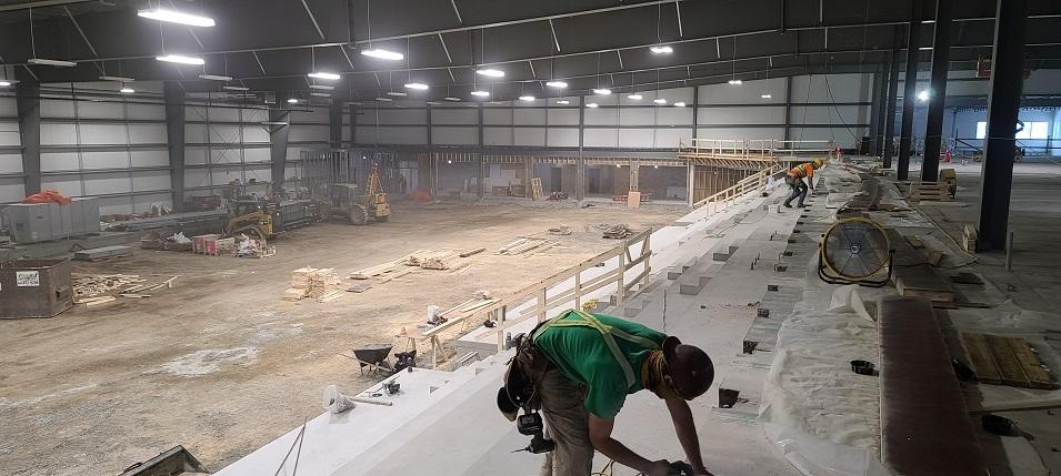 Photo 11: Construction workers in the arena seating area.