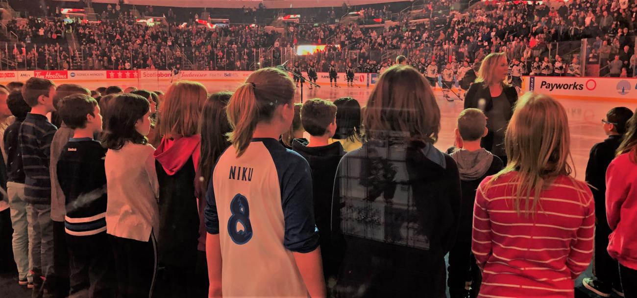 Music teacher Susan Simcoe leads the Niverville Elementary School choir in singing the national anthem at Bell MTS Place on November 17.