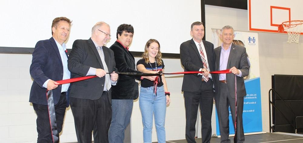 The ribbon-cutting ceremony, with MLA Ron Schuler, Minister of Education Kelvin Goertzen, students Dominic Augusto and Katey Hiebert, Mayor Myron Dyck, and MP Ted Falk.