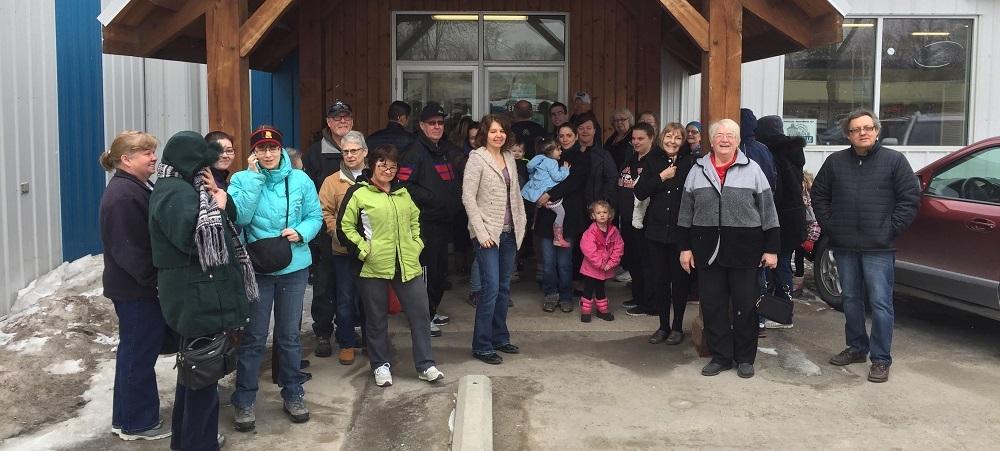 A crowd of eager shoppers gathers outside the thrift store on a chilly Tuesday morning.