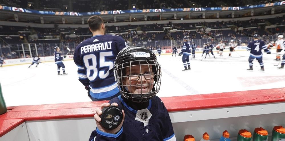 Ryder Couzens of Niverville sits on the bench at a Jets home game warm-up.
