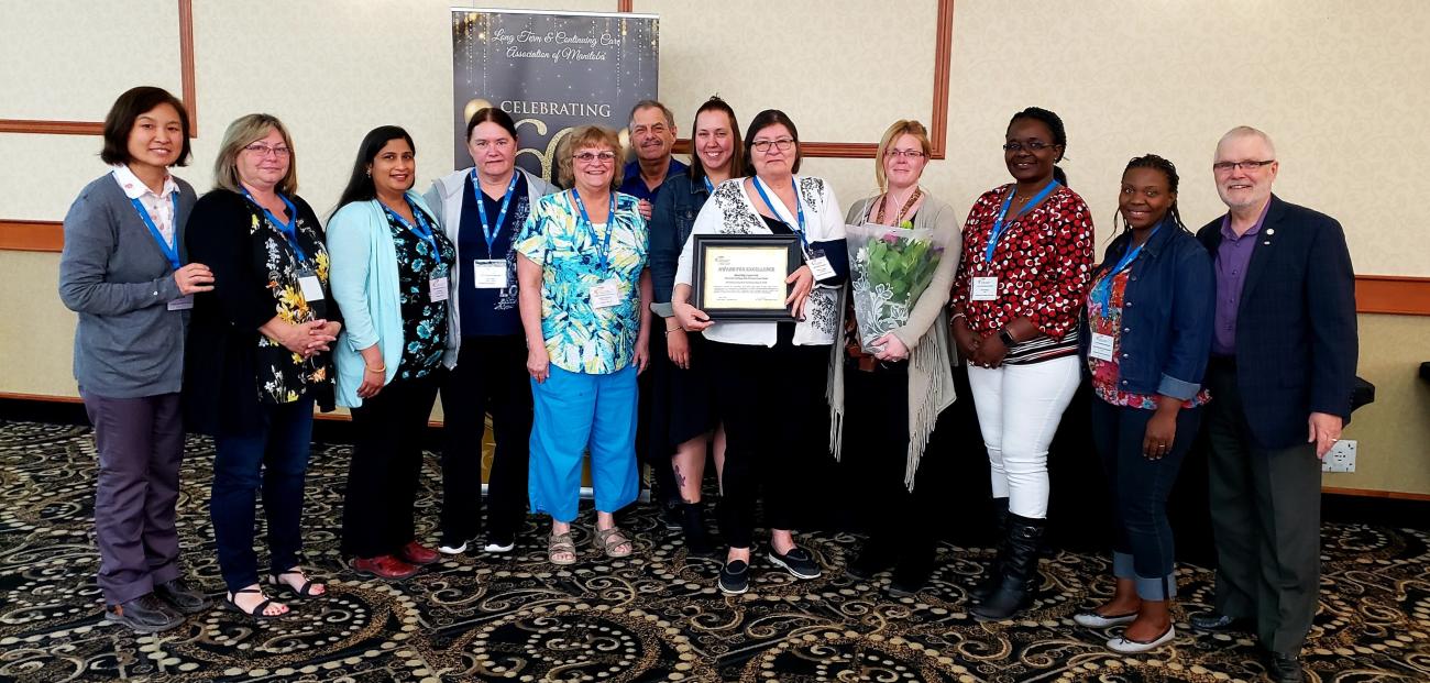 Team members of the Heritage Life Personal Care Home, with Dorothy Lapointe holding her award certificate.