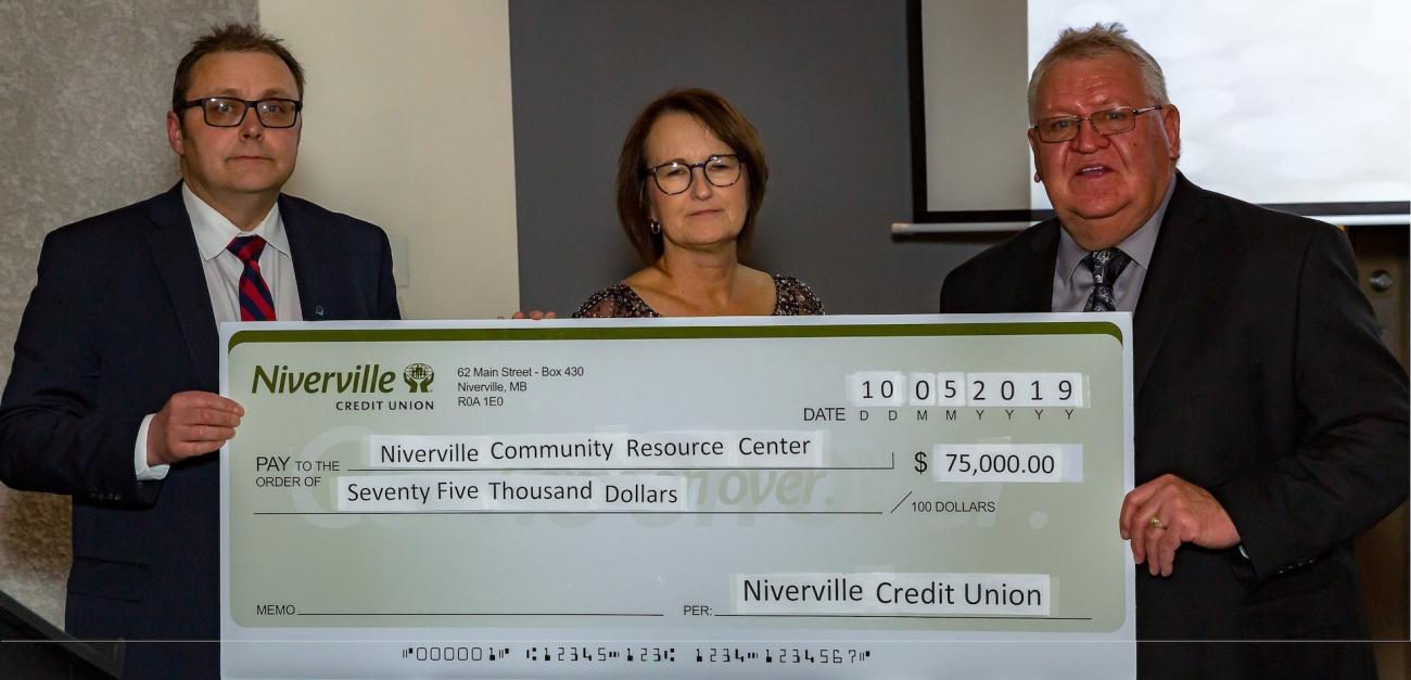Ken Rempel and Nancy Penner of the Niverville Credit Union present a cheque to fundraising co-chair Clarence Braun.