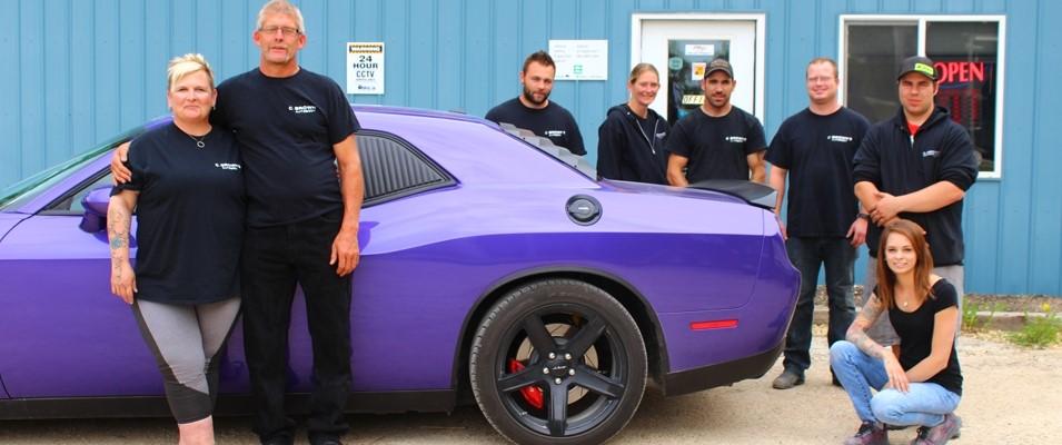 Carol Brown with her husband Brian and autobody staff.