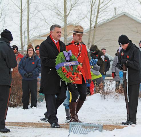 MP Ted Falk lays a wreath at a Remembrance Day ceremony in Lorette
