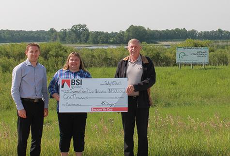 BSI's Ryan Haps and Jake Neufeld present a cheque to Nicole DePauw, Tourond Creek Committee Treasurer