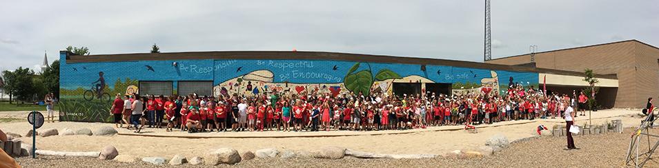 Students celebrate the completion of the Canada 150 mural at Ecole St. Adolphe School
