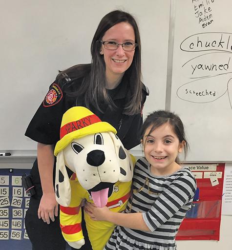 Calysta Guenette poses alongside Sparky the Fire Dog and paramedic firefighter Tara Fehr