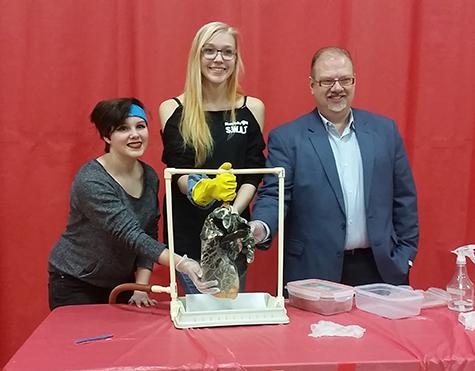 Kianne Prudhomme, Shelah Klassen, and the Hon. Kelvin Goertzen examine a mock-up of a diseased lung