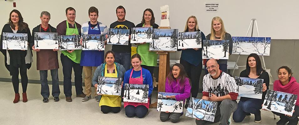 Paint night participants who off their art.