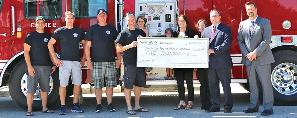 Ron Ashcroft of NCU presents cheque to Deputy Fire Chief Brad Wasilinchuk